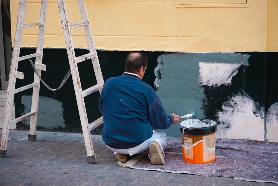 Painter cutting in along the base of a wall with a brush