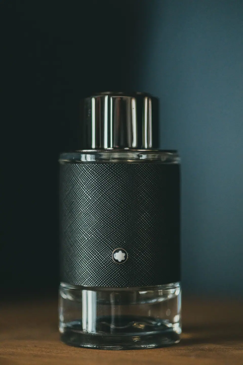 Fragrance bottle on a dark teal backdrop