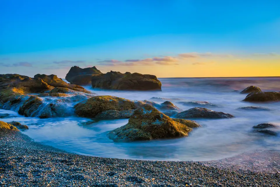 Long exposure waves around rocks at sunset