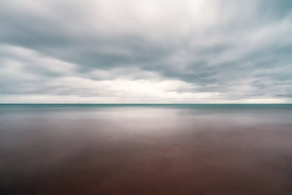 Long exposure of a calm sea under overcast sky