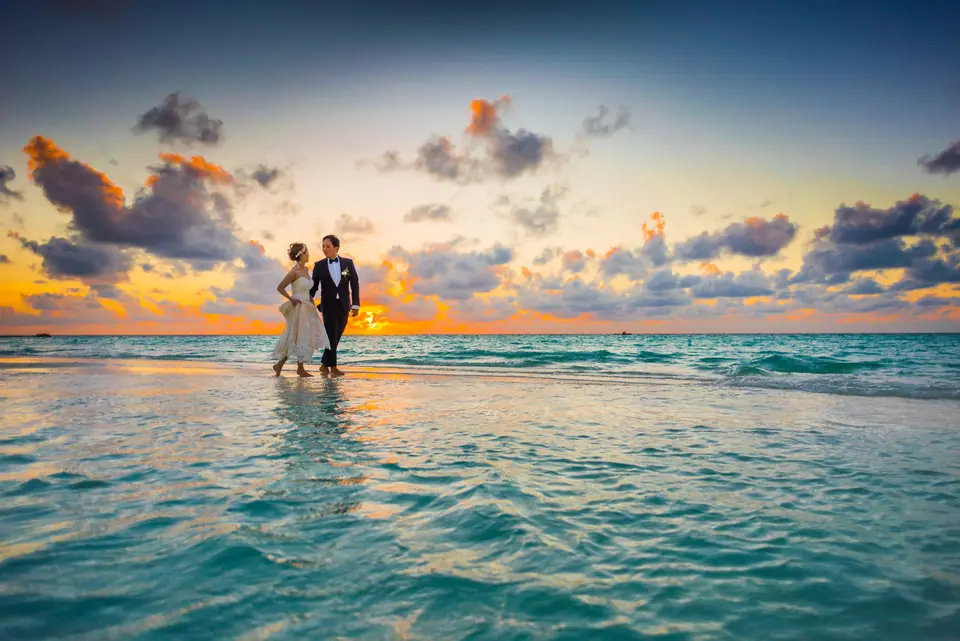 Couple walking along the shore at sunset