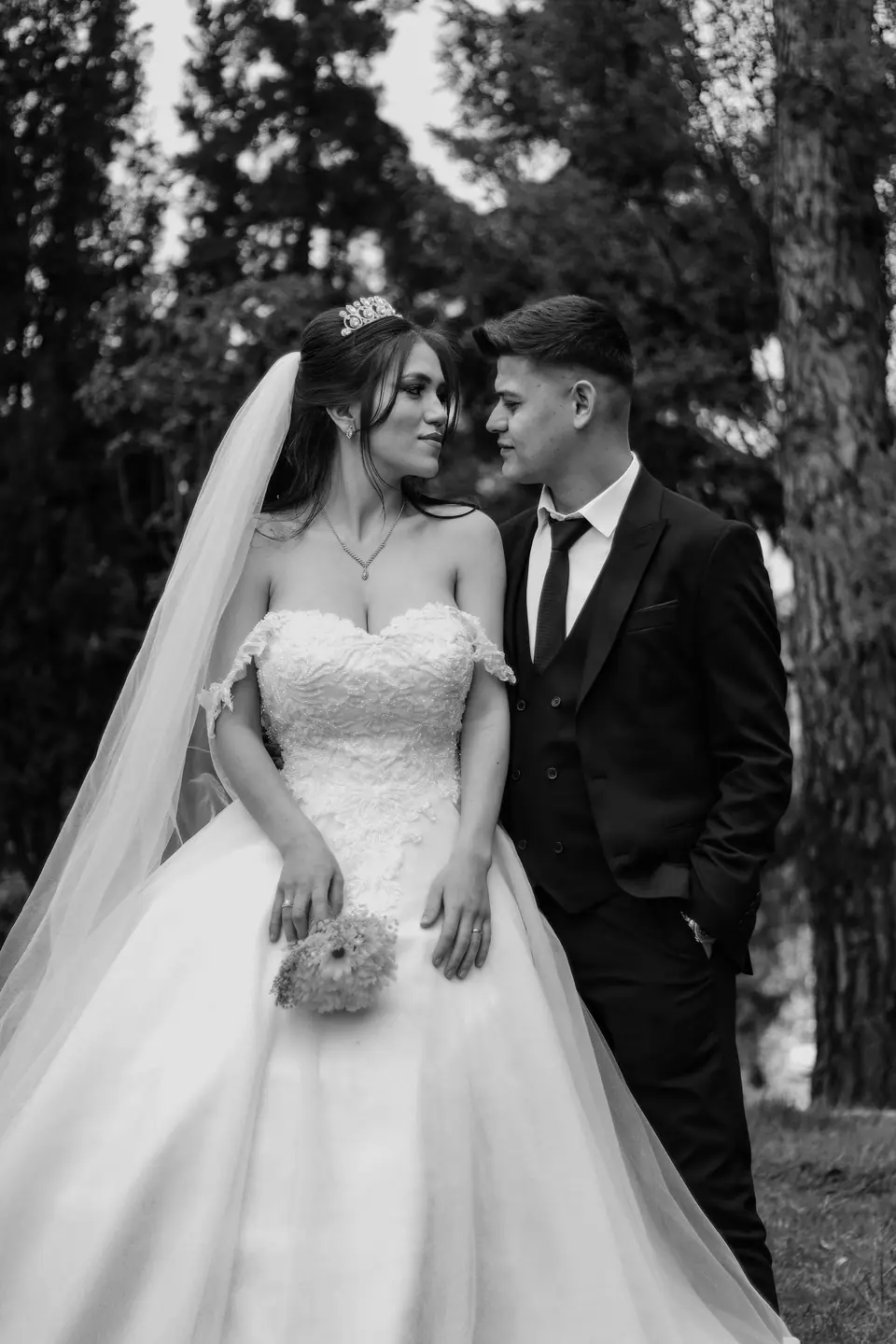 Bride and groom outdoors among pines, black and white