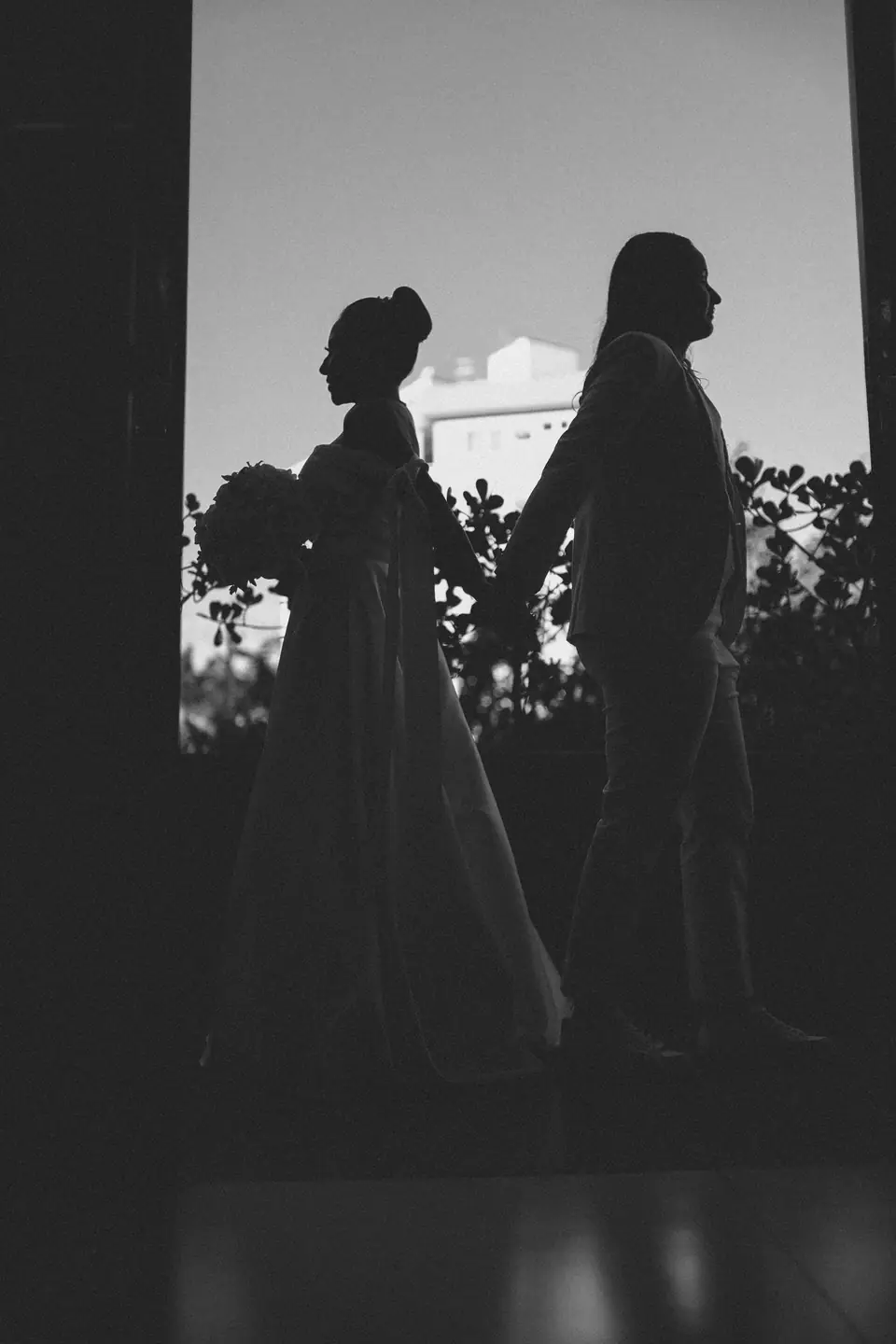Silhouette of a bride and groom holding hands